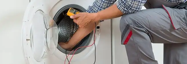 Dryer repair technician inspecting and repairing a clothes dryer in Evansville, IN