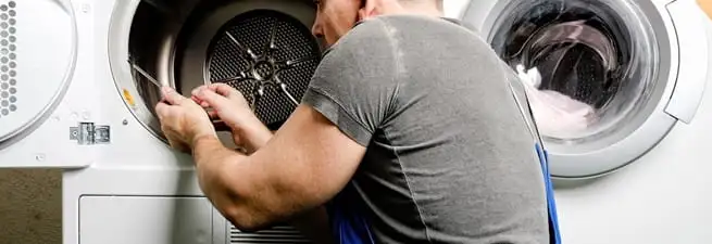 Dryer repair technician fixing a clothes dryer drum in Evansville, IN