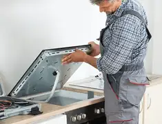 Appliance repair technician installing a built-in cooktop in Evansville, IN