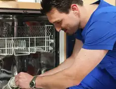 Dishwasher repair technician inspecting and servicing an open dishwasher in Evansville, IN