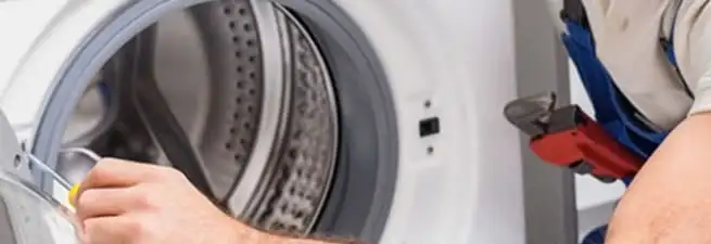 Appliance technician repairing a clothes dryer drum and internal parts in Evansville, IN