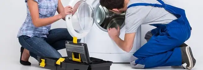 Washer repair technician inspecting a front-load washing machine with tools in Evansville, IN