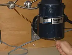 Garbage disposal repair technician tightening the mounting ring under a sink in Evansville, IN