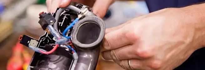 Vacuum repair technician reconnecting wiring and components in Evansville, IN