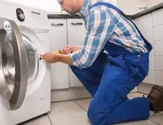 Washing machine repair technician servicing a front-load washer in Evansville, IN