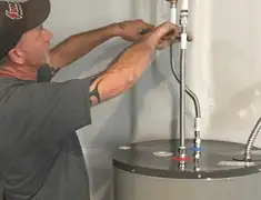 Water heater repair technician tightening supply line connections in Evansville, IN