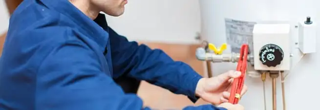 Water heater repair technician adjusting the temperature control and gas valve in Evansville, IN